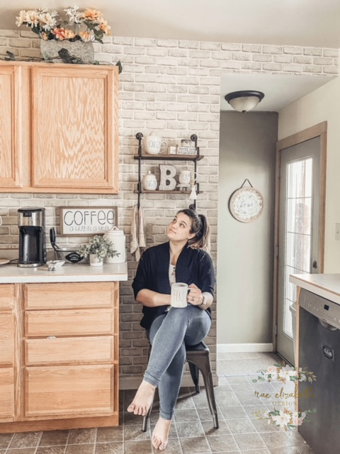 woman in kitchen with brick walls