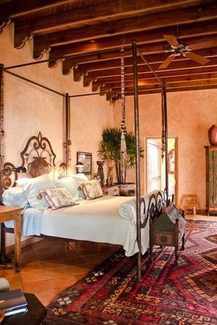 a mexican themed bedroom with an iron canopy bed