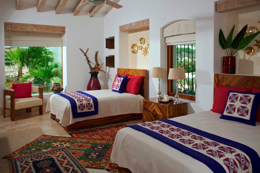 a Mexican bedroom with two beds decorated with bold colors