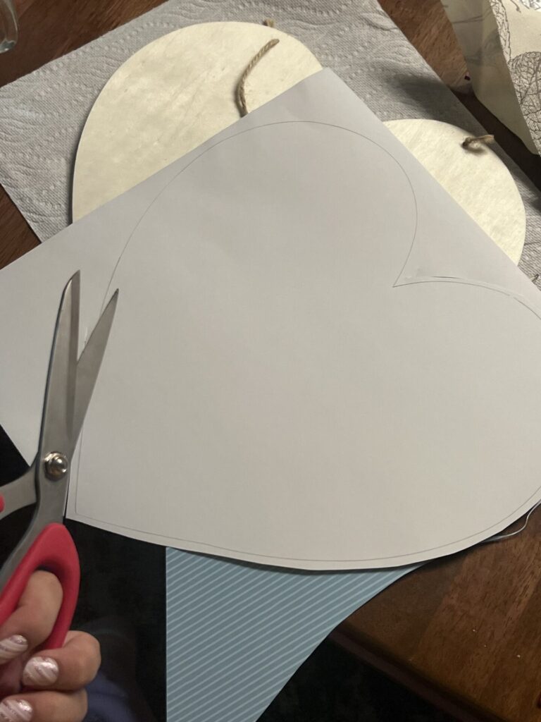 a view of scissors getting ready to cut some paper with a heart shape traced onto it