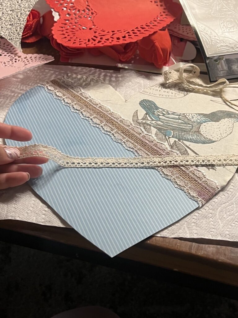 another small off white ribbon getting added to the heart decoration