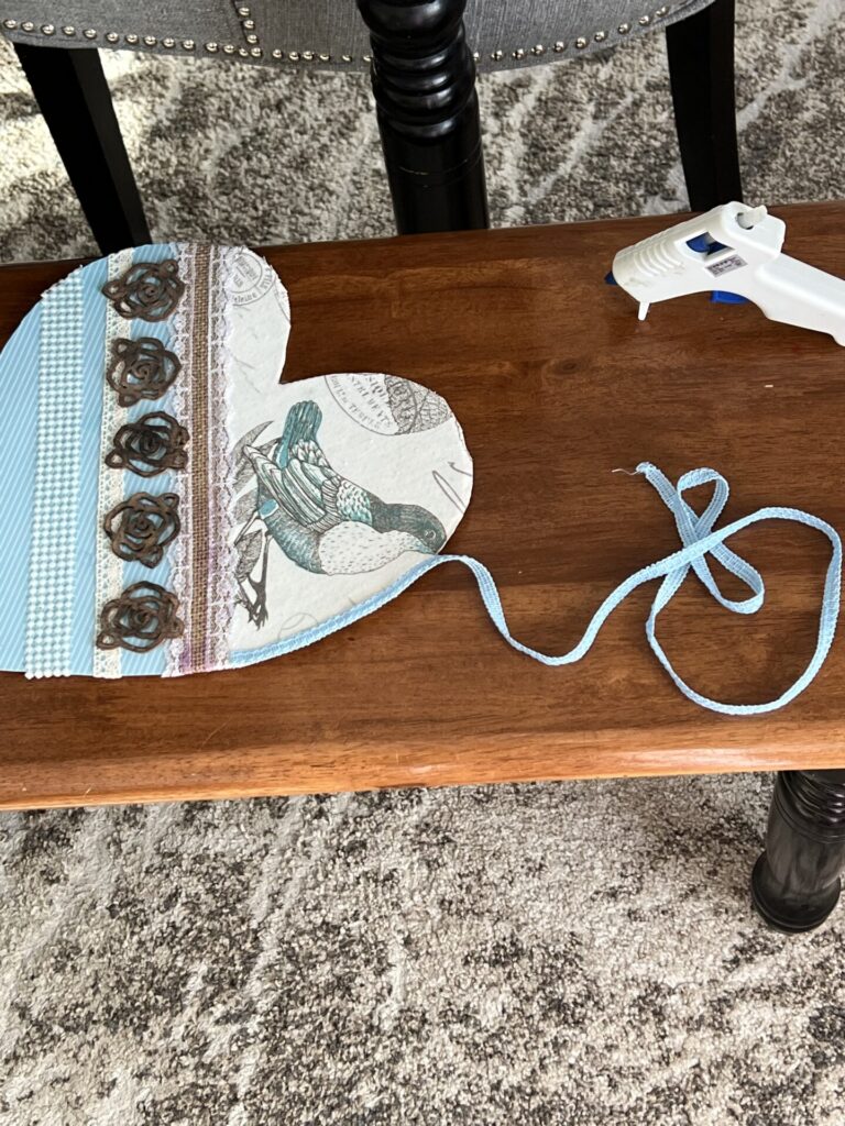 adding blue ribbon along the edges of the heart craft