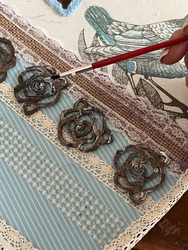painting a light coat of white to the wooden roses