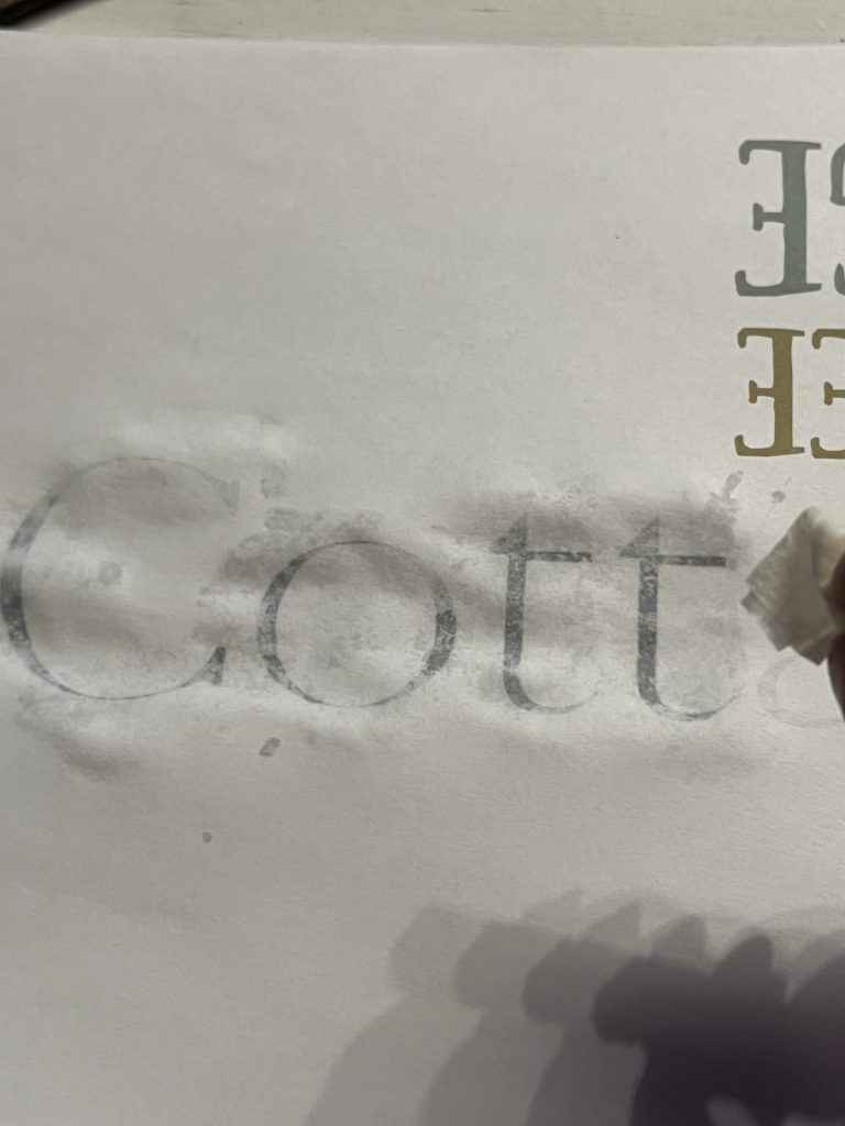 a close up view of a piece of paper and the lettering being lightly dampened