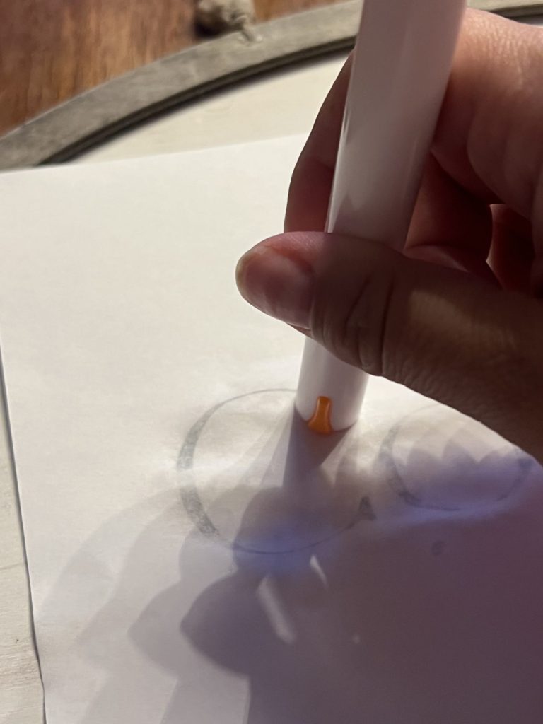 pressing lightly onto the lettering with the back of a marker