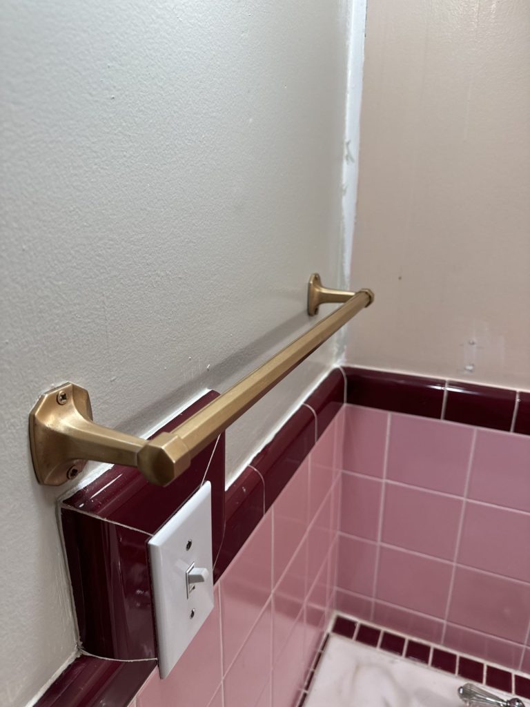 a gold towel bar in a bathroom