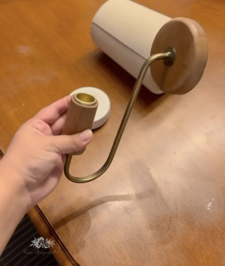 a hand holding a candle stick holder for the wall