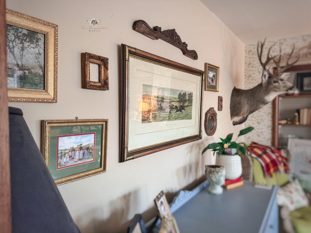 A living room gallery wall of a vintage art collection